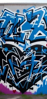 Blue and black graffiti heart on urban wall art.