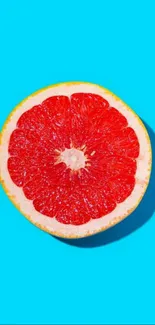 Vibrant grapefruit on bright blue background wallpaper.