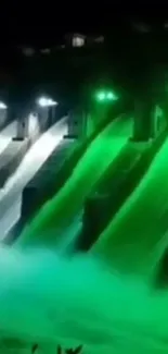 Vibrant green lit dam at night scene