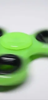 Dynamic green fidget spinner on white background.