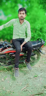 Man sitting on a motorcycle with a green background.