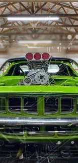 Green muscle car with exposed engine in a wooden garage setting.