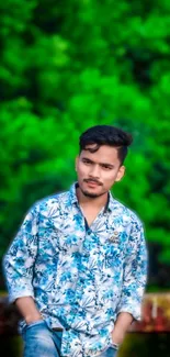 Person in floral shirt standing before vibrant green foliage.