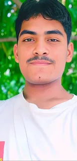 Smiling young man with a lush green background, bright and refreshing.