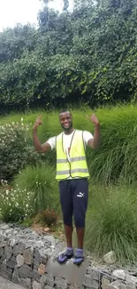 Person in garden with lush green background wearing a yellow vest.