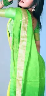 Elegant woman in vibrant green saree posing gracefully.