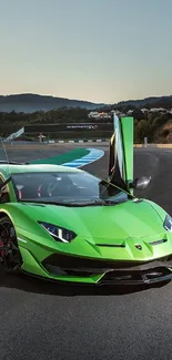 A vibrant green sports car with open doors on a scenic track.