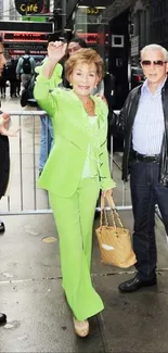 Person in lime green suit on a city street with others.