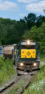 Train moving through lush green landscape under a clear blue sky.