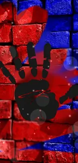 Red and blue brick wall with black handprint art.