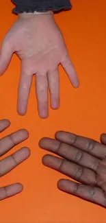 Three hands on an orange background.