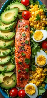 Colorful salad bowl with salmon, avocado, corn, and eggs on a blue plate.