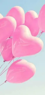 Pink heart-shaped balloons float against a clear blue sky.