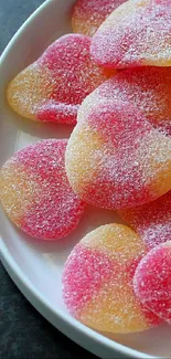 Heart-shaped candies in pink and orange hues on a plate.