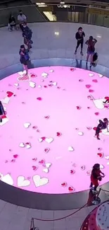 Vibrant pink circle with hearts on a public display.