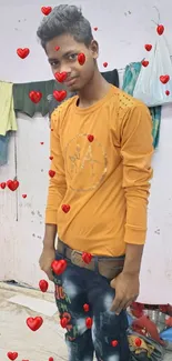 Man in orange shirt with red hearts wallpaper.