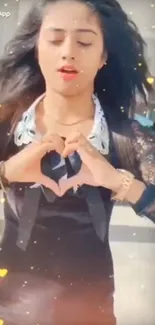 Woman holding heart gesture, surrounded by colorful sparkles.