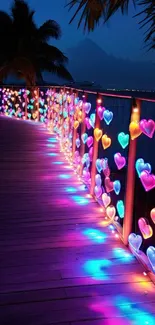 Colorful heart-shaped lights on a boardwalk at night.