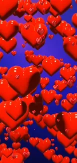 Glossy red hearts float on blue background creating a vibrant, romantic wallpaper.