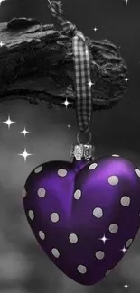 Purple heart ornament with polka dots on a branch.