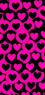 Vibrant pink heart pattern on a black background wallpaper.