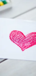 Red crayon heart drawing on white paper background.