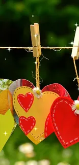 Colorful hearts hanging on a clothesline in nature.