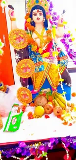 Colorful Hindu deity with offerings and floral decor.