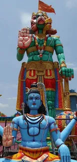 Vibrant Hindu deities statue with blue skies.