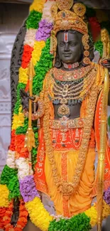 Hindu deity statue adorned with colorful garlands and ornaments, vibrant display.