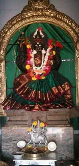 Intricate Hindu goddess statue with vibrant colors and golden frame.