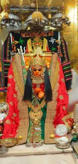 Intricate Hindu goddess shrine with red and gold adornments.