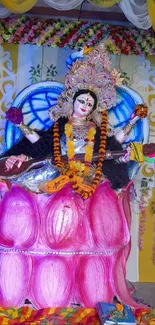 Hindu goddess seated on a pink lotus with floral decorations.