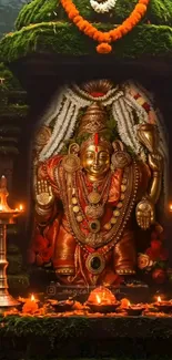 Golden deity sculpture in a Hindu temple with candles and flowers.