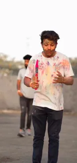 Young man celebrates Holi festival with colorful powders.