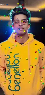 Man in a yellow hoodie with confetti background on mobile wallpaper.