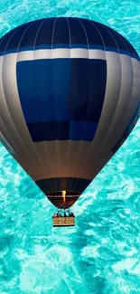 Vibrant hot air balloon over turquoise water.