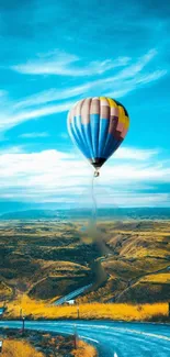 Hot air balloon over fields and sky.