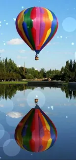 Colorful hot air balloon reflecting on a calm lake under blue sky.