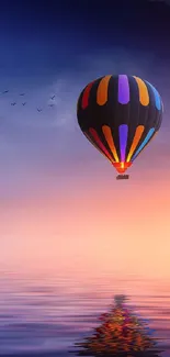 Colorful hot air balloon over calm sunset waters.