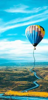 Hot air balloon floating over scenic landscape in vibrant colors.