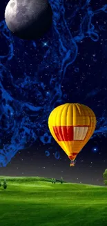 Colorful hot air balloon under a moonlit sky with green fields.