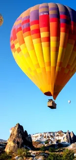 Vibrant hot air balloons against a blue sky over a scenic landscape.