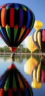 Colorful hot air balloons over a calm lake reflecting the blue sky.