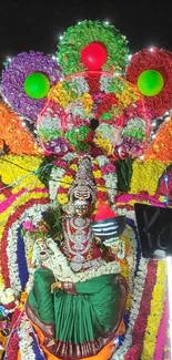 Colorful Indian festival decor with deity and flowers.