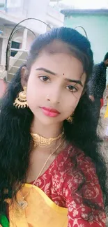 Woman in vibrant yellow saree with traditional jewelry.