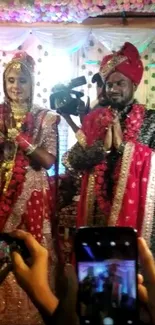 Indian bride and groom in traditional attire under a festively decorated canopy.