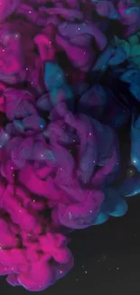 Vibrant abstract ink swirl in magenta and teal hues on a dark background.