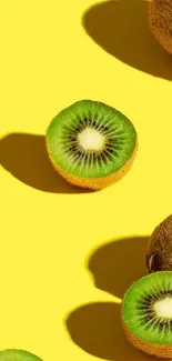 Vivid kiwi fruit on bright yellow background wallpaper.