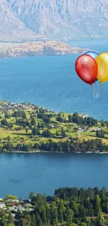 Colorful balloons float over scenic lake with mountains.